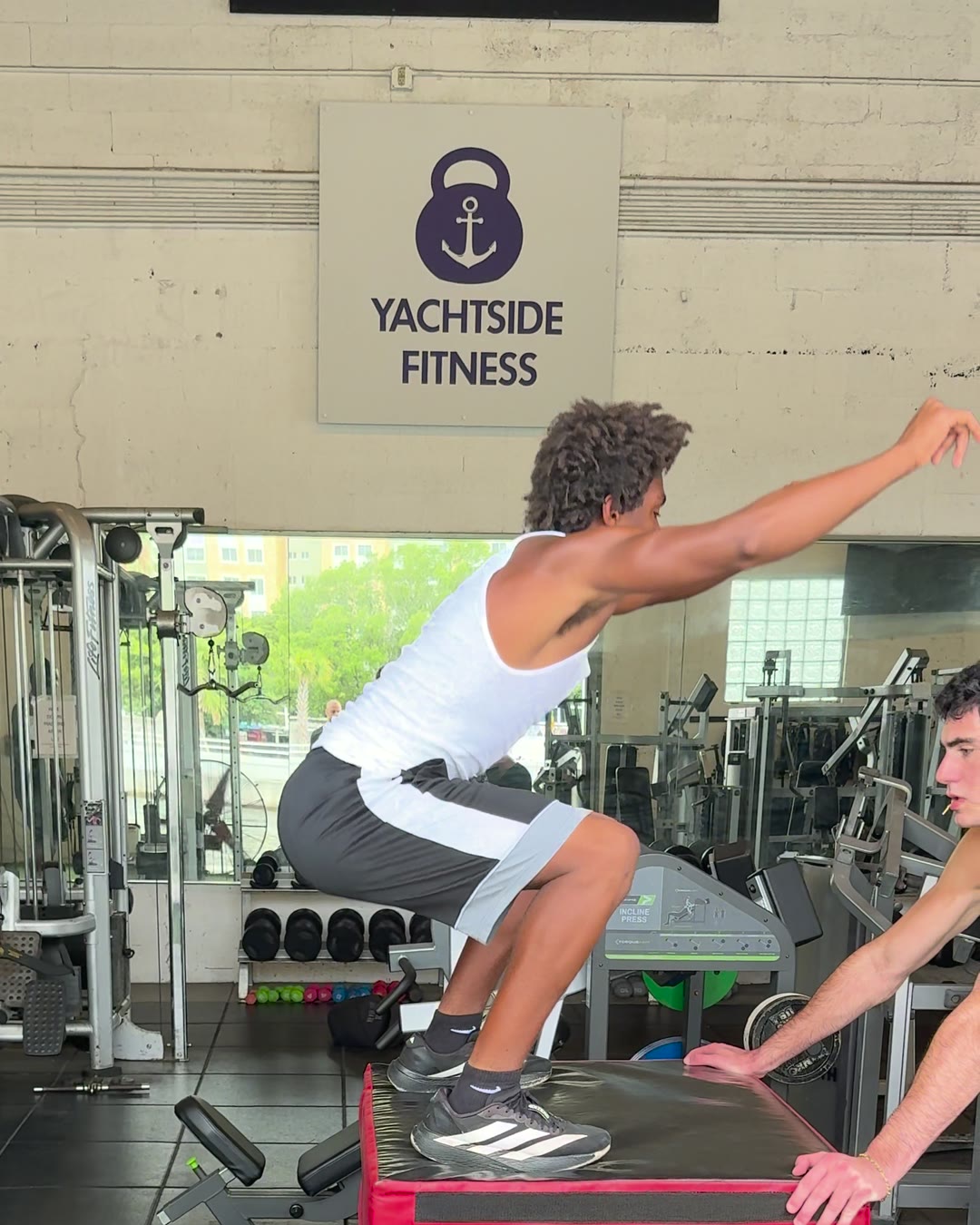 Dr. Evan Motlong coaching an athlete through an explosive box jump during return-to-sport rehab